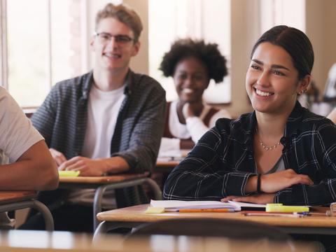 College aged students sitting at desks.