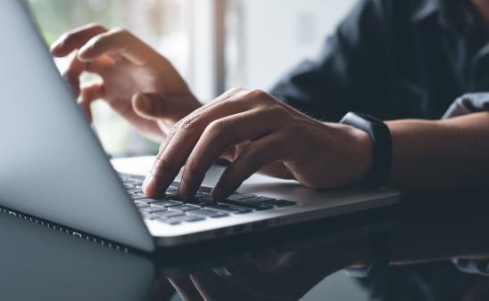 hands typing on computer