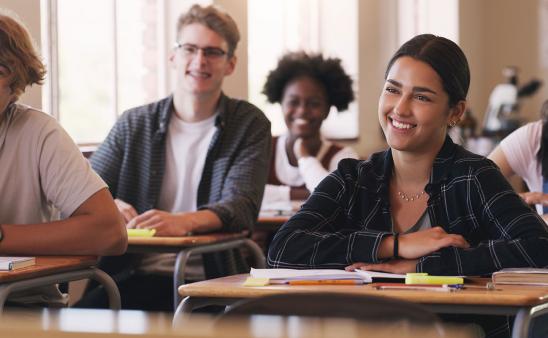 College aged students sitting at desks.